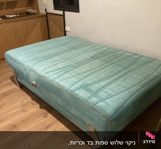 ספה ירוקה בחדר עם רצפת עץ